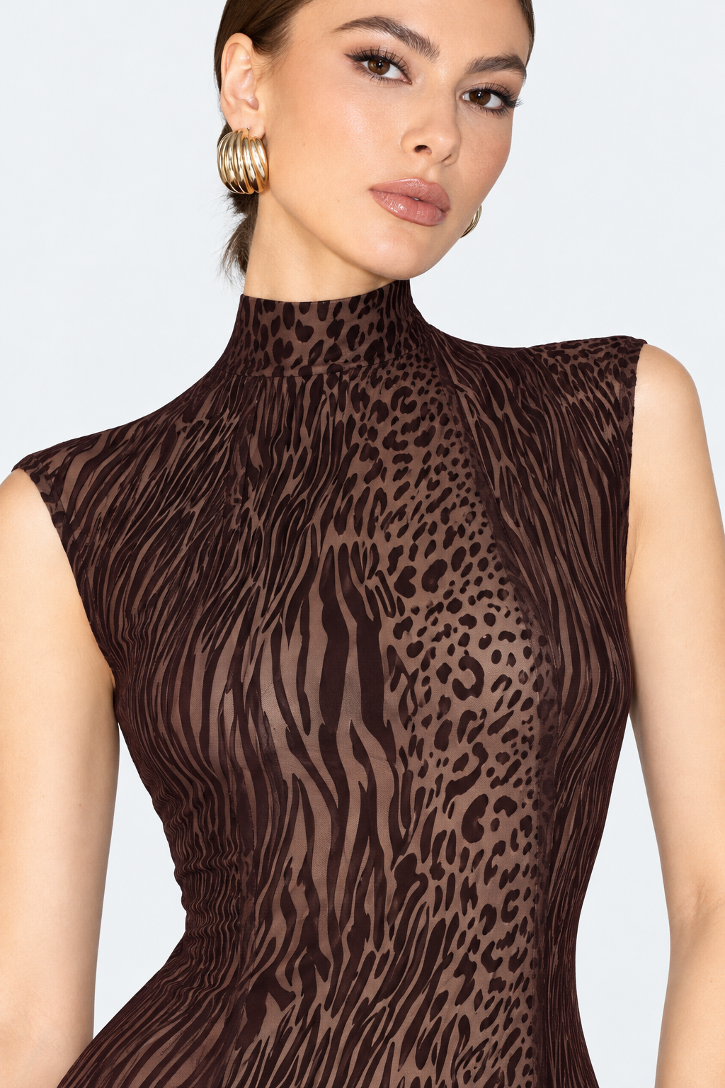 Close-up of the brown animal-print dress showing the high neckline and mixed leopard and stripe pattern.