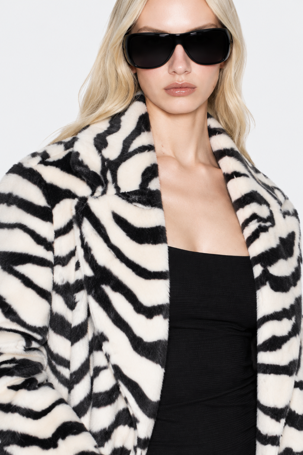 Detail of the black and ivory zebra-patterned plush fabric and wide collar.